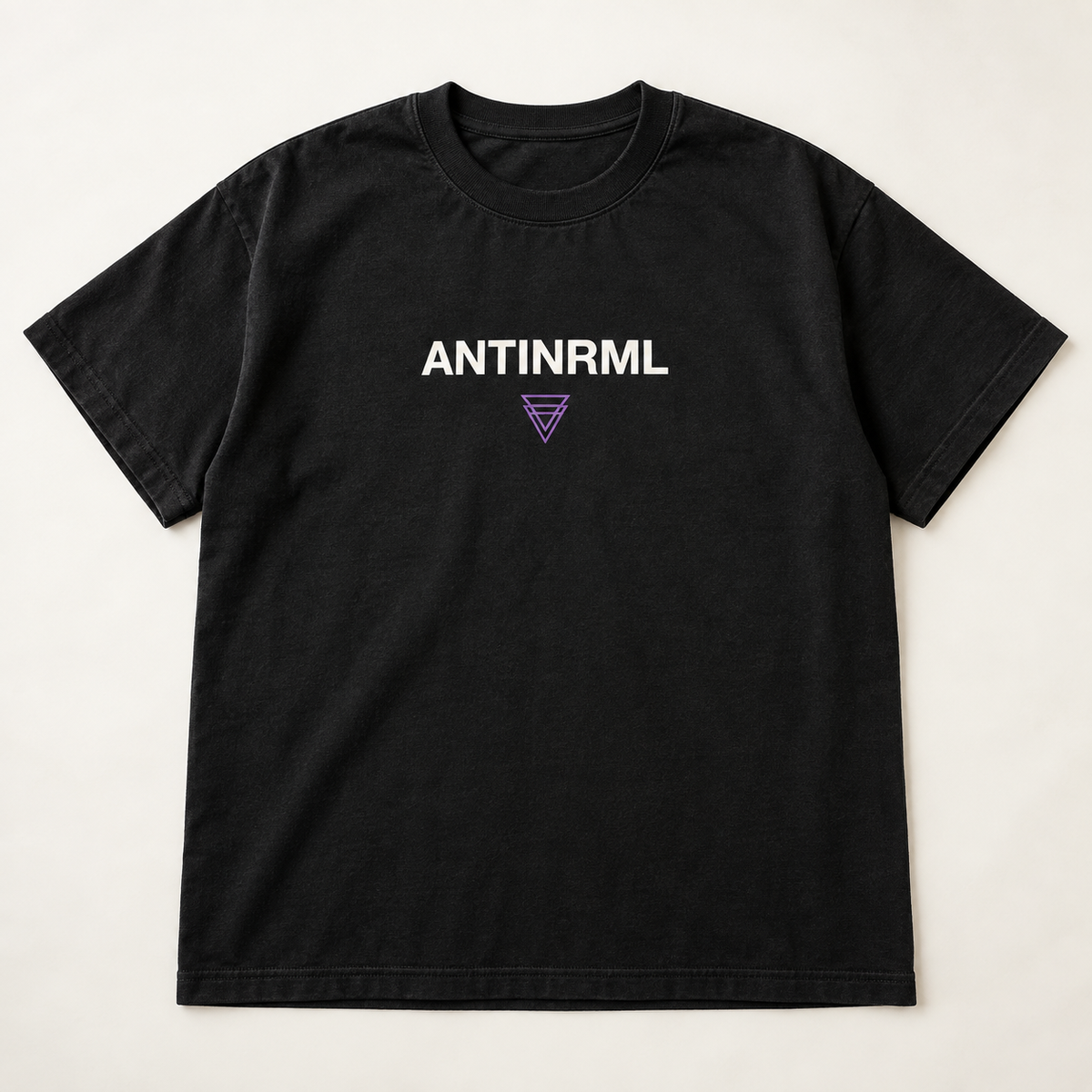 Mockup konsep AntiNRML Logo Tee — desain merch sementara, bukan foto barang produksi.